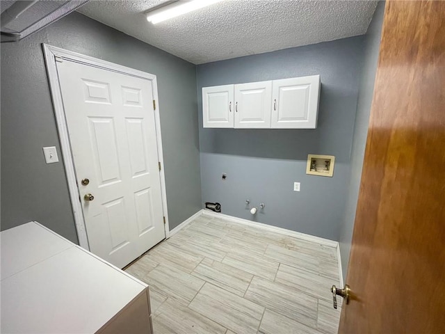 washroom with washer hookup, hookup for a gas dryer, cabinet space, hookup for an electric dryer, and a textured ceiling