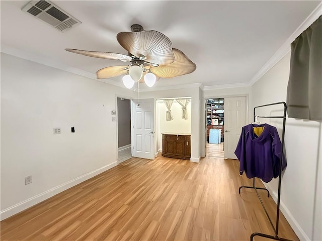 unfurnished bedroom featuring light wood-type flooring, baseboards, visible vents, and ornamental molding