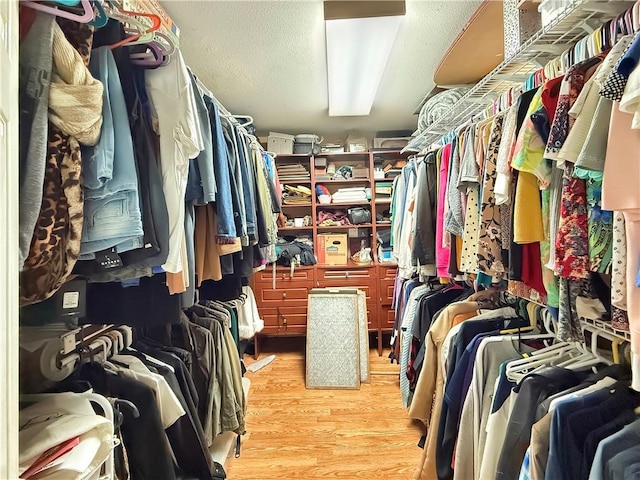 walk in closet with light wood-style flooring