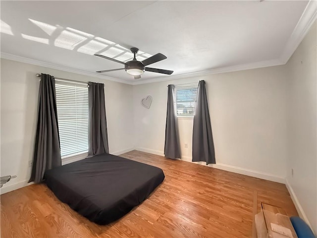 bedroom with ceiling fan, baseboards, light wood-style floors, and ornamental molding