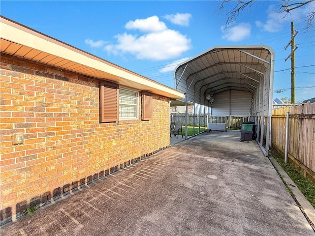 view of parking featuring a carport, driveway, and fence