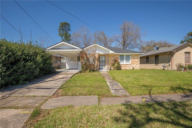 view of front of property featuring brick siding, an attached carport, a front lawn, driveway, and a gate