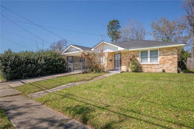 view of front of home with a front lawn and brick siding