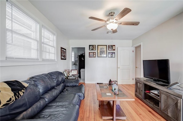 living area featuring visible vents, light wood finished floors, and ceiling fan