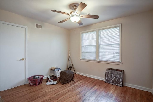 misc room featuring visible vents, baseboards, wood finished floors, and a ceiling fan