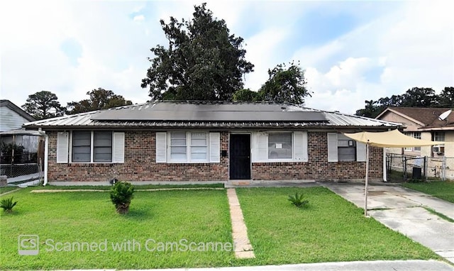 single story home featuring a front yard, fence, brick siding, and metal roof