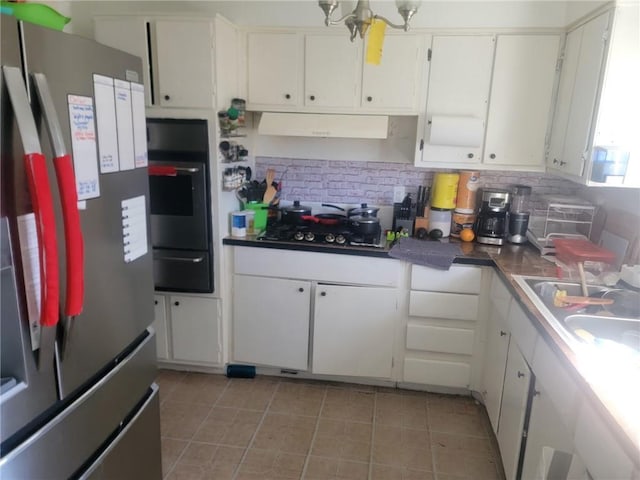 kitchen with a warming drawer, tasteful backsplash, appliances with stainless steel finishes, and white cabinets