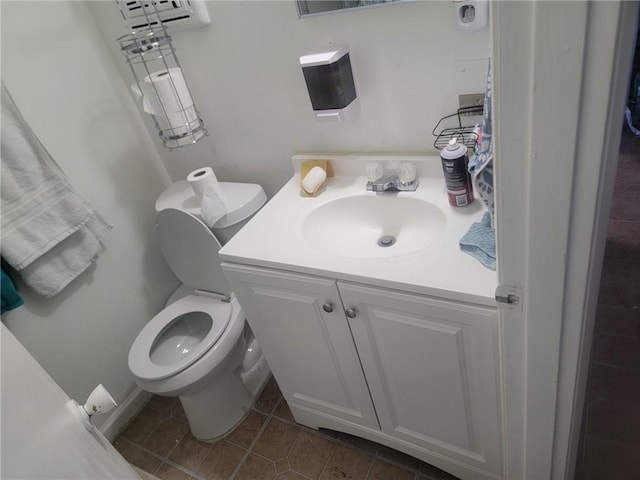 half bathroom with toilet, vanity, and tile patterned flooring