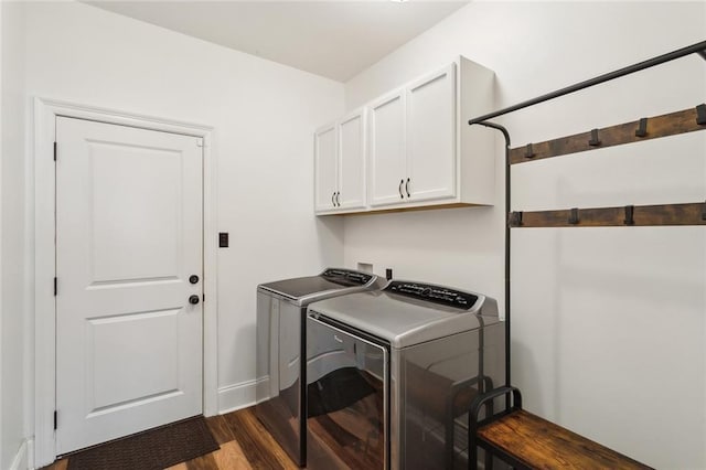 washroom featuring washer and clothes dryer, cabinet space, and dark wood-style flooring