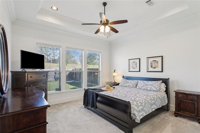 bedroom featuring visible vents, light carpet, a tray ceiling, crown molding, and baseboards