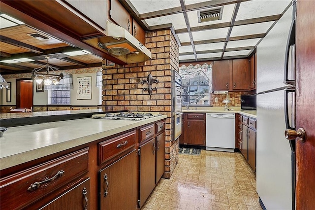 kitchen with visible vents, white appliances, light countertops, and decorative backsplash