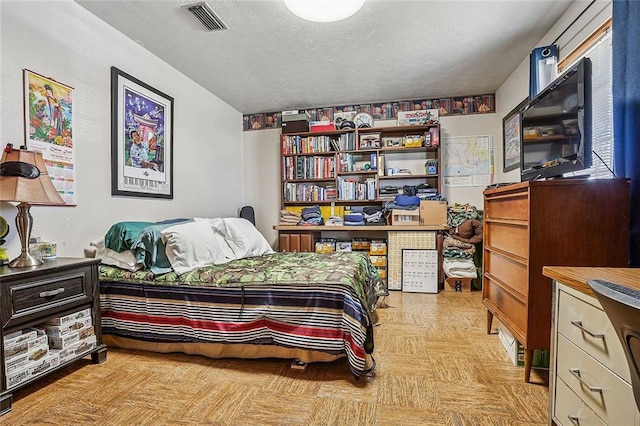 bedroom featuring visible vents and a textured ceiling