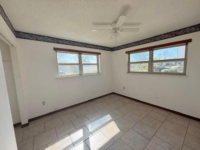 empty room with baseboards, a textured ceiling, and ceiling fan