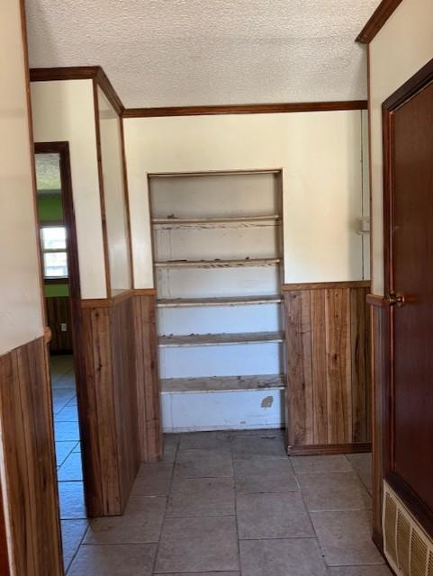 hall with visible vents, wainscoting, and wood walls