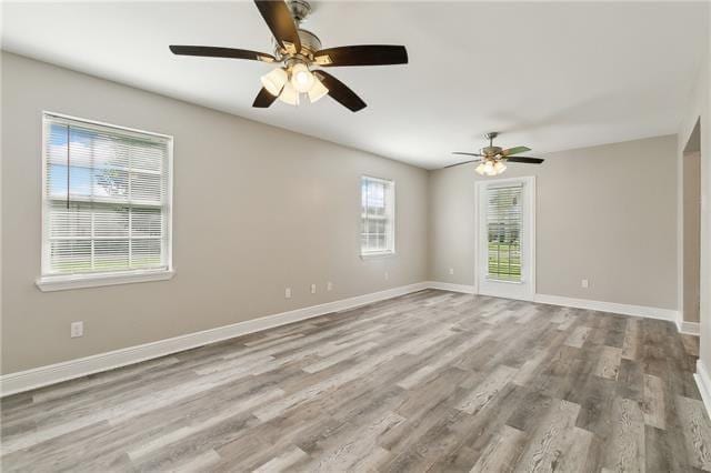 spare room with ceiling fan, baseboards, and wood finished floors