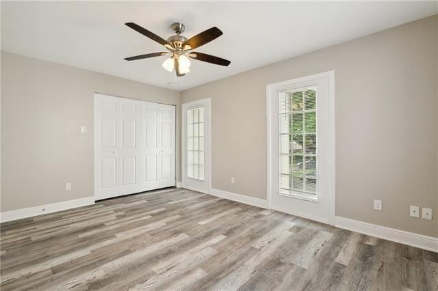 unfurnished bedroom featuring a closet, baseboards, and wood finished floors