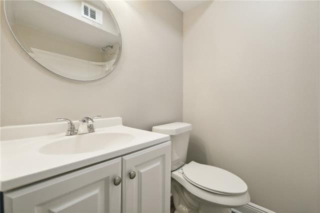 half bathroom featuring visible vents, toilet, and vanity