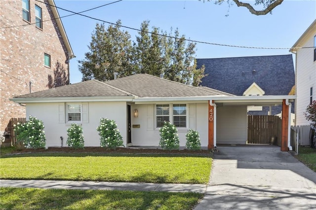 ranch-style house featuring stucco siding, a front lawn, fence, concrete driveway, and a carport