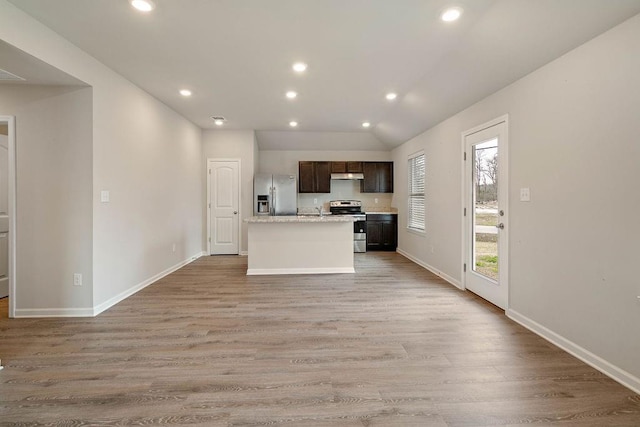 kitchen featuring light wood-style flooring, under cabinet range hood, stainless steel appliances, light countertops, and dark brown cabinets