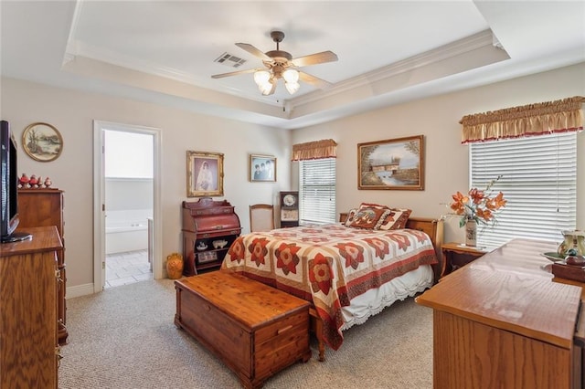 bedroom with a tray ceiling, crown molding, light colored carpet, and visible vents