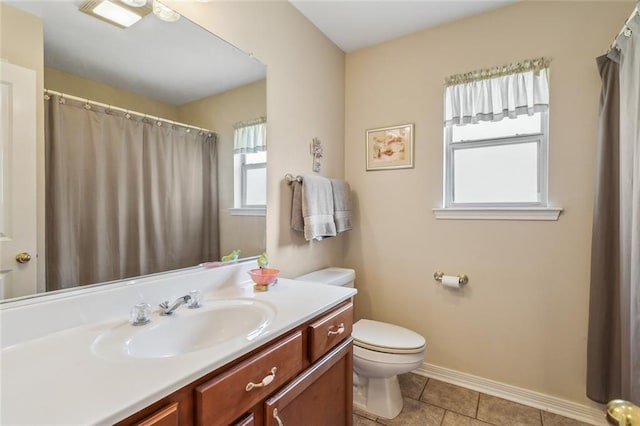 bathroom featuring baseboards, toilet, vanity, and tile patterned flooring