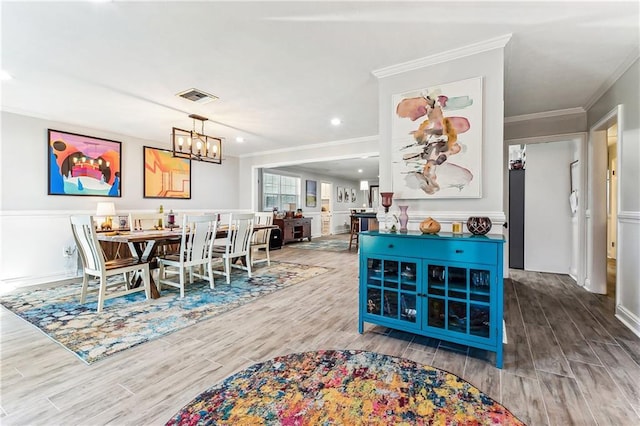 dining space featuring visible vents, wood finished floors, recessed lighting, crown molding, and a chandelier