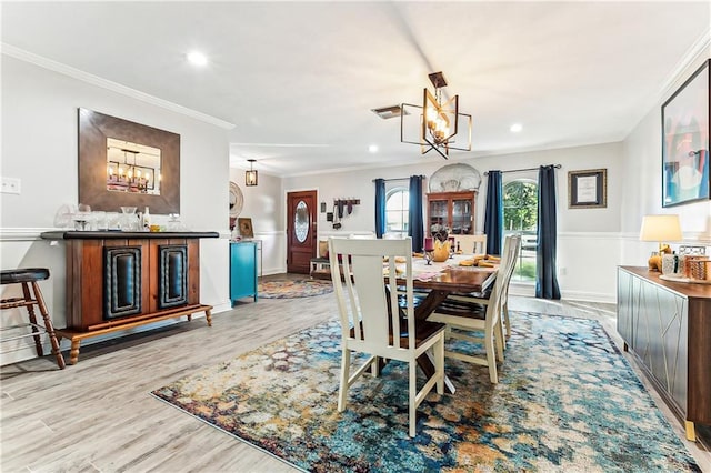 dining space with recessed lighting, light wood-style flooring, a chandelier, and crown molding