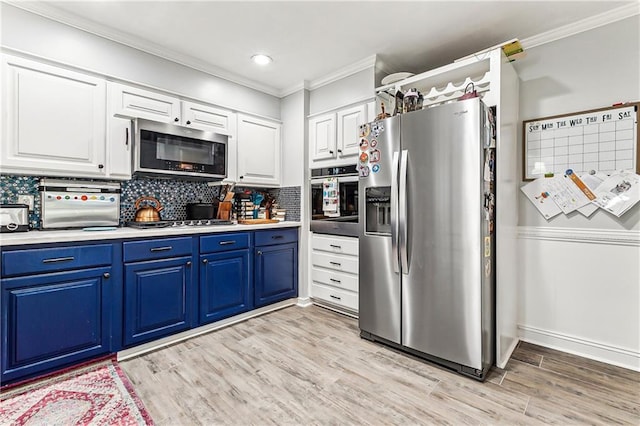 kitchen with light wood-style flooring, blue cabinetry, stainless steel appliances, white cabinets, and decorative backsplash