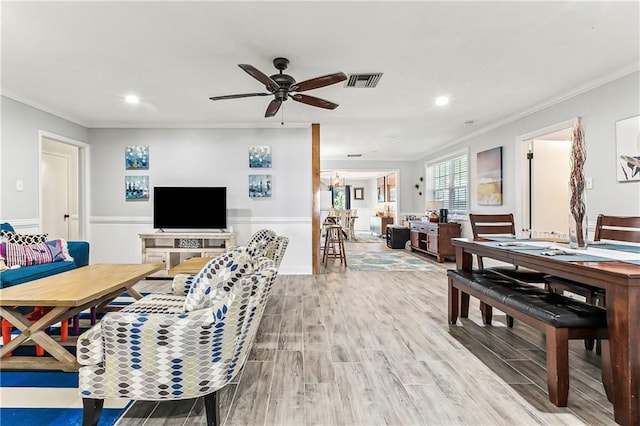 living room with a ceiling fan, visible vents, light wood finished floors, recessed lighting, and ornamental molding