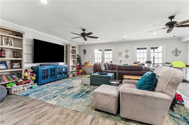 living area with french doors, crown molding, and wood finished floors