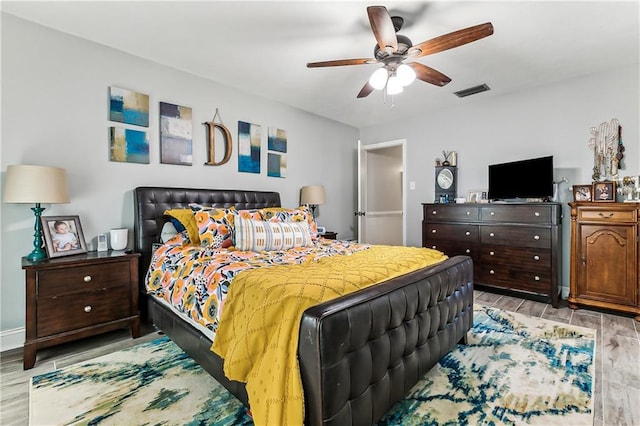 bedroom with ceiling fan, baseboards, visible vents, and wood tiled floor