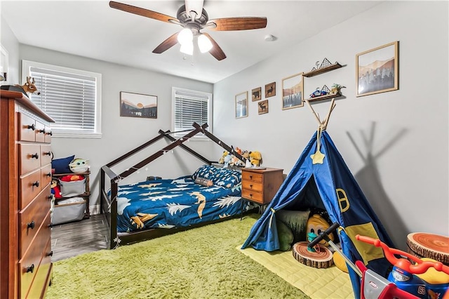 bedroom with baseboards, wood finished floors, and a ceiling fan