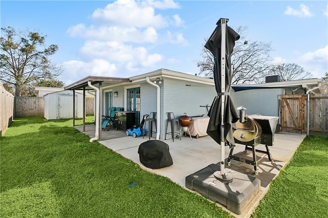 rear view of property featuring a patio, a storage shed, a fenced backyard, and an outdoor structure