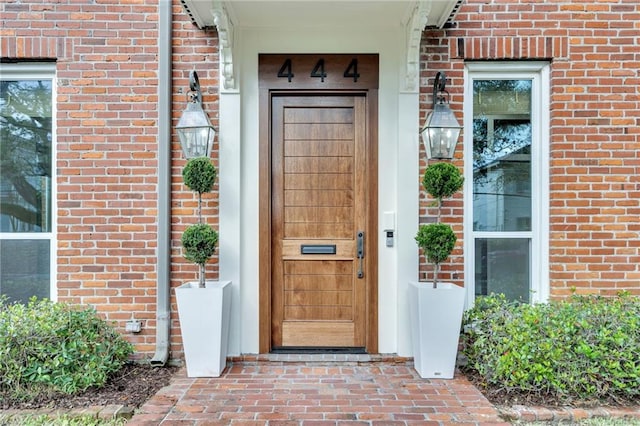 entrance to property featuring brick siding