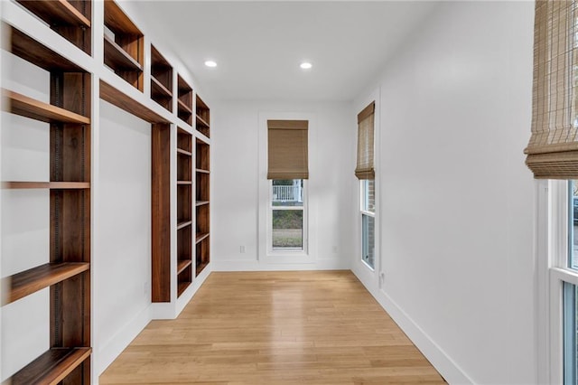 hall with recessed lighting, light wood-type flooring, and baseboards