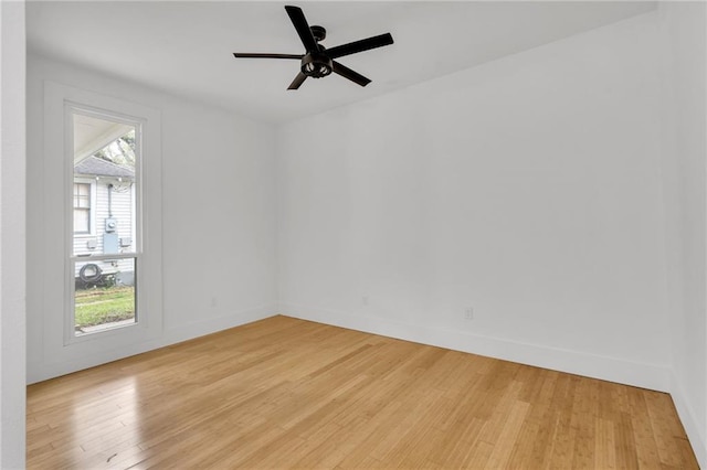 unfurnished room featuring baseboards, a ceiling fan, and light wood finished floors