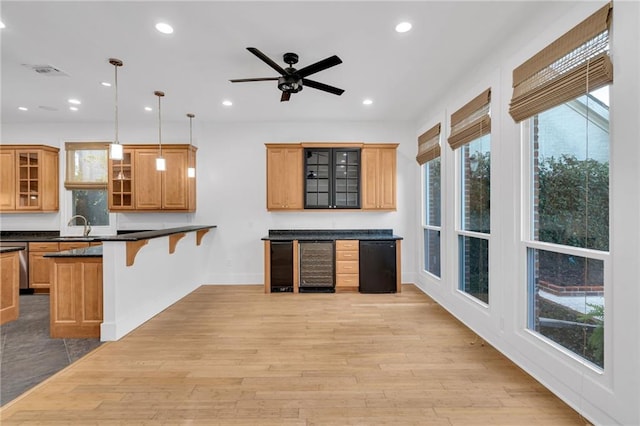 kitchen with visible vents, recessed lighting, light wood-style floors, a kitchen bar, and dark countertops