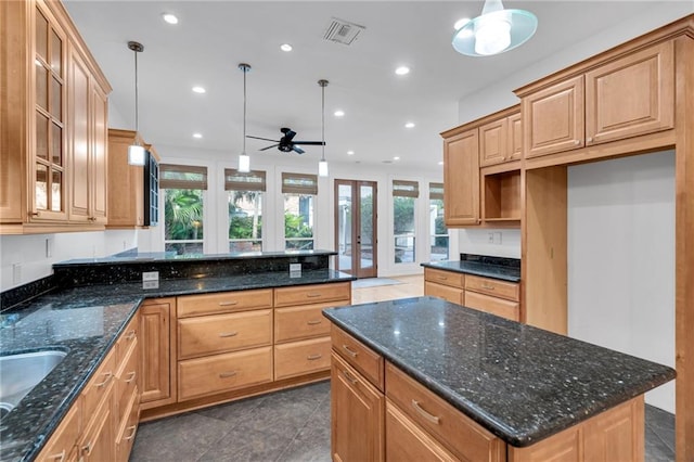 kitchen featuring visible vents, glass insert cabinets, decorative light fixtures, recessed lighting, and a ceiling fan