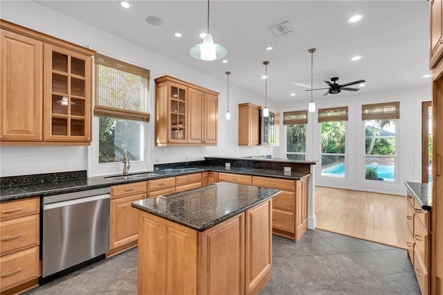 kitchen featuring visible vents, a sink, a kitchen island, a peninsula, and dishwasher