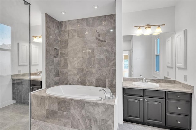 full bathroom featuring a sink, two vanities, a bath, and tile patterned floors