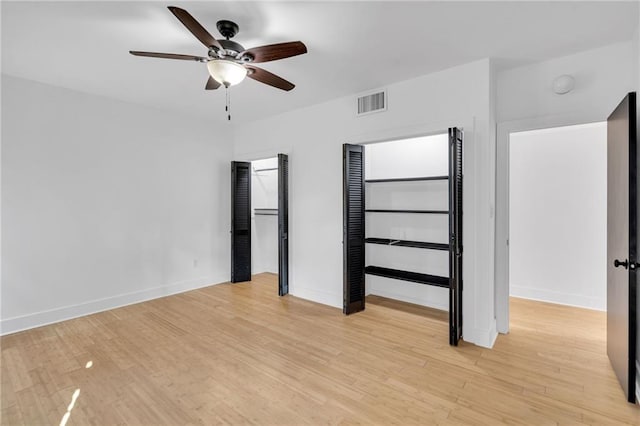 unfurnished bedroom with ceiling fan, visible vents, baseboards, and light wood-style flooring