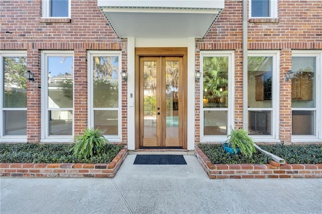 property entrance featuring brick siding and french doors