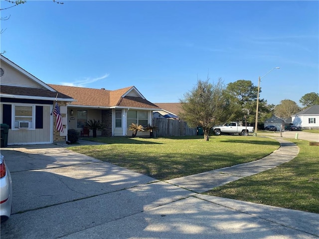 view of front facade featuring cooling unit, a shingled roof, a front yard, and fence