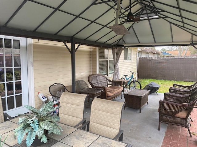 view of patio / terrace with a gazebo, an outdoor living space, and fence