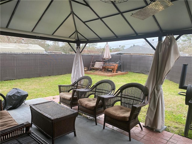 view of patio featuring a gazebo, fence, and an outdoor living space