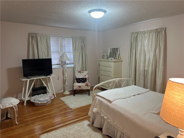 bedroom featuring a textured ceiling and wood finished floors