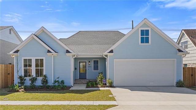 view of front of house with concrete driveway, a garage, fence, and a front yard