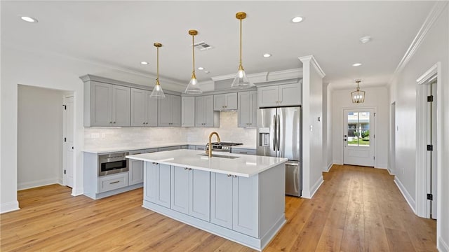 kitchen featuring light wood-type flooring, stainless steel fridge, gray cabinetry, and light countertops