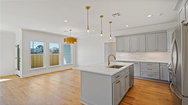 kitchen featuring visible vents, gray cabinets, a sink, tasteful backsplash, and stainless steel appliances