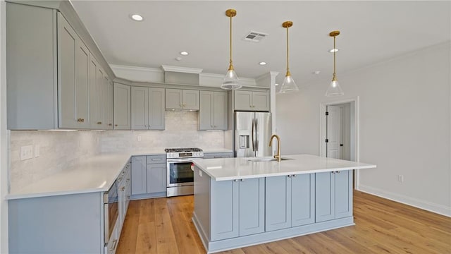 kitchen featuring visible vents, gray cabinets, a sink, light countertops, and appliances with stainless steel finishes